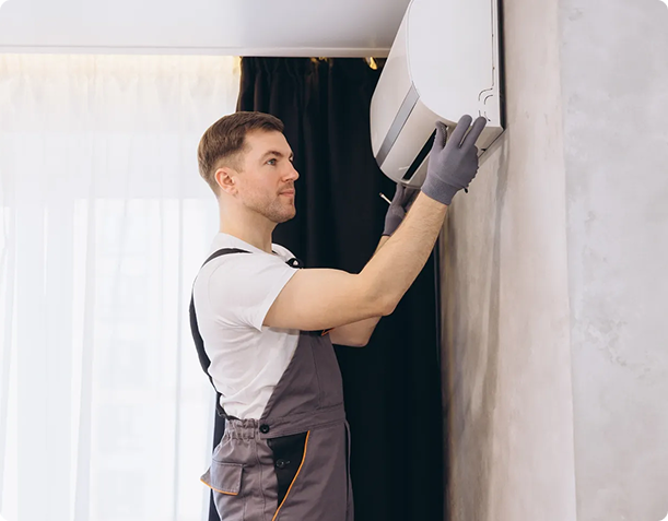 Man adjusting wall-mounted air conditioner